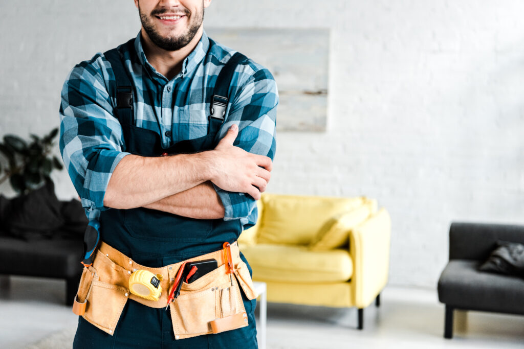 cropped view of happy worker standing with crossed arms